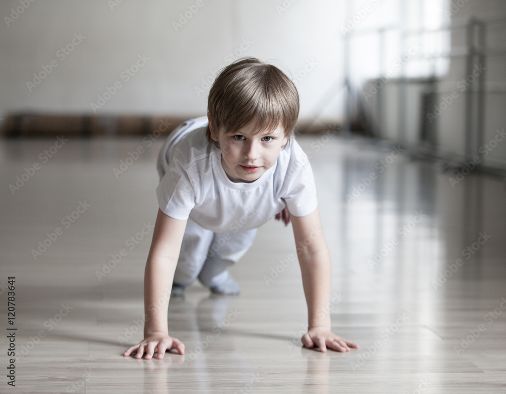Cute boy in white clothes practicing capoeira (brazilian martial art that combines elements of dance, acrobatics and music) in gym
Cute boy in white clothes practicing capoeira (brazilian martial art that combines elements of dance, acrobatics and music) in gym