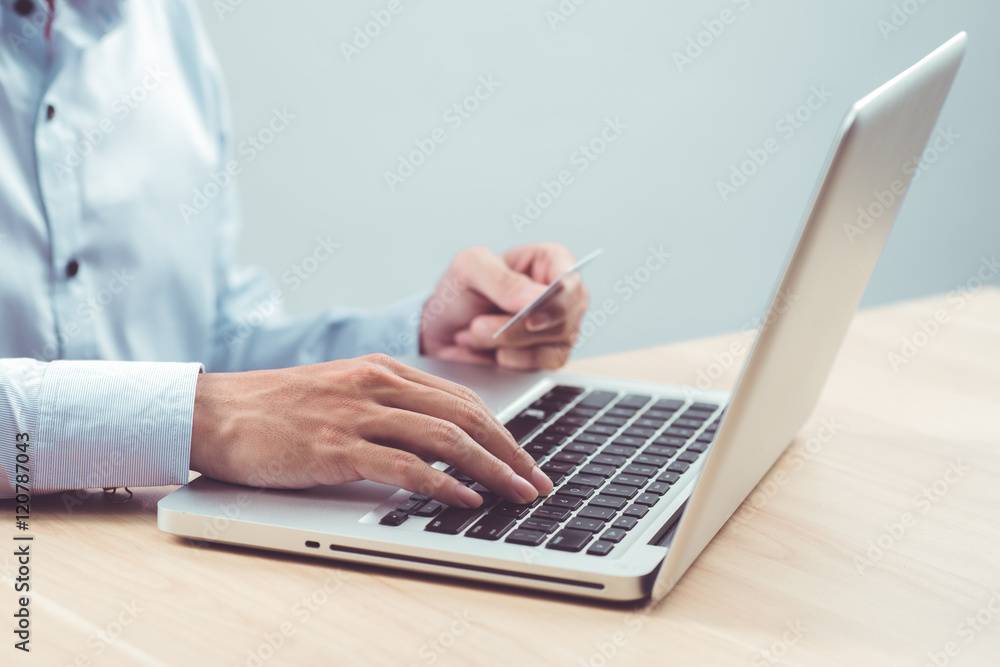 Hands holding plastic credit card and using laptop. Online shopp Hands holding plastic credit card and using laptop. Online shopp