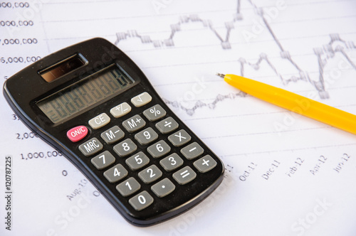 Calculator on the desk, pen, calculations. Finance