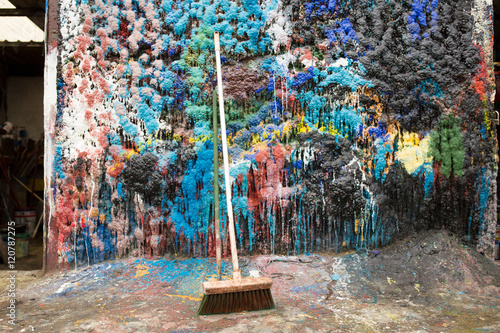 Broom leaning against paint splattered wall in ship painting boatyard