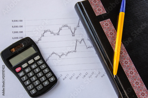 Calculator on the desk pen, calculations, chart, notebook, diary