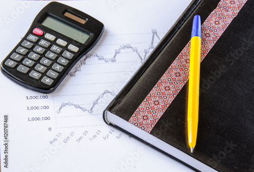 Calculator on the desk pen, calculations, chart, notebook, diary
