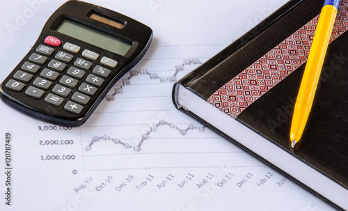 Calculator on the desk pen, calculations, chart, notebook, diary