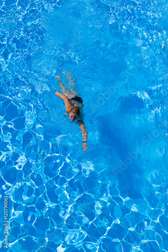 woman with swimsuit swimming on a blue water pool © Netfalls