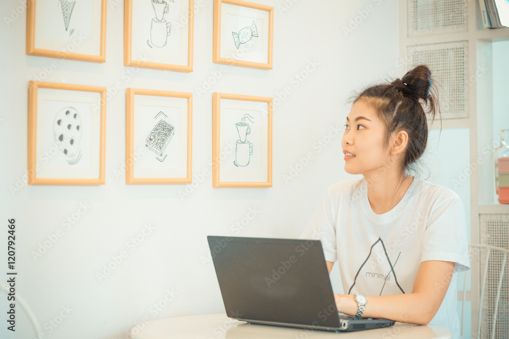 Asian beautiful student woman with laptop and cellphone in cozy Asian beautiful student woman with laptop and cellphone in cozy