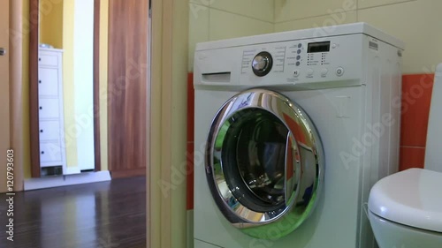 Wallpaper Mural small child puts laundry in the washing machine Torontodigital.ca