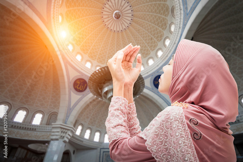 Photos Veiled Islamic woman wearing a burka standing in a beam of overhead light in atm
