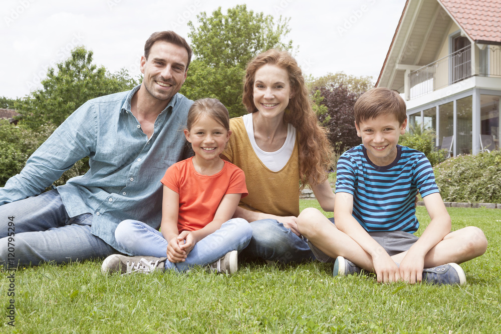 Portrait of smiling family sitting in garden Portrait of smiling family sitting in garden