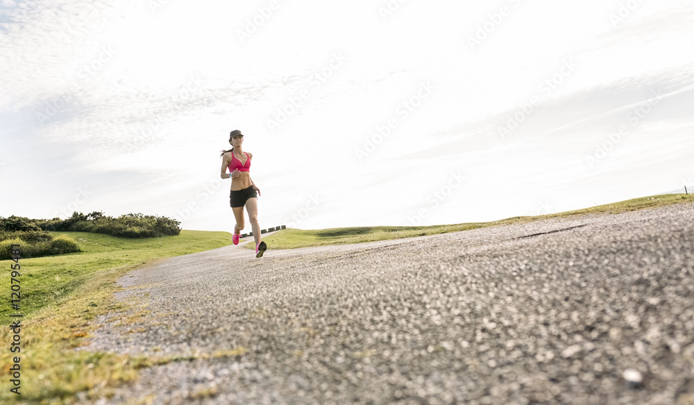 Female runner training on country road Female runner training on country road