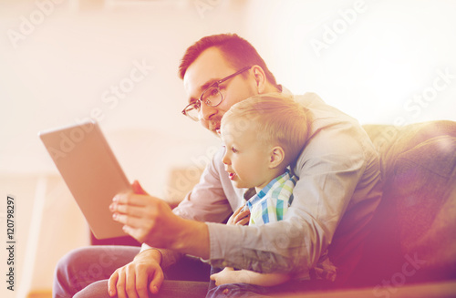Fotografie father and son with tablet pc playing at home