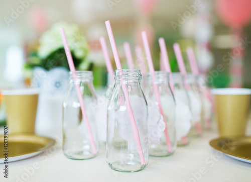 close up of glass bottles for drinks with straws