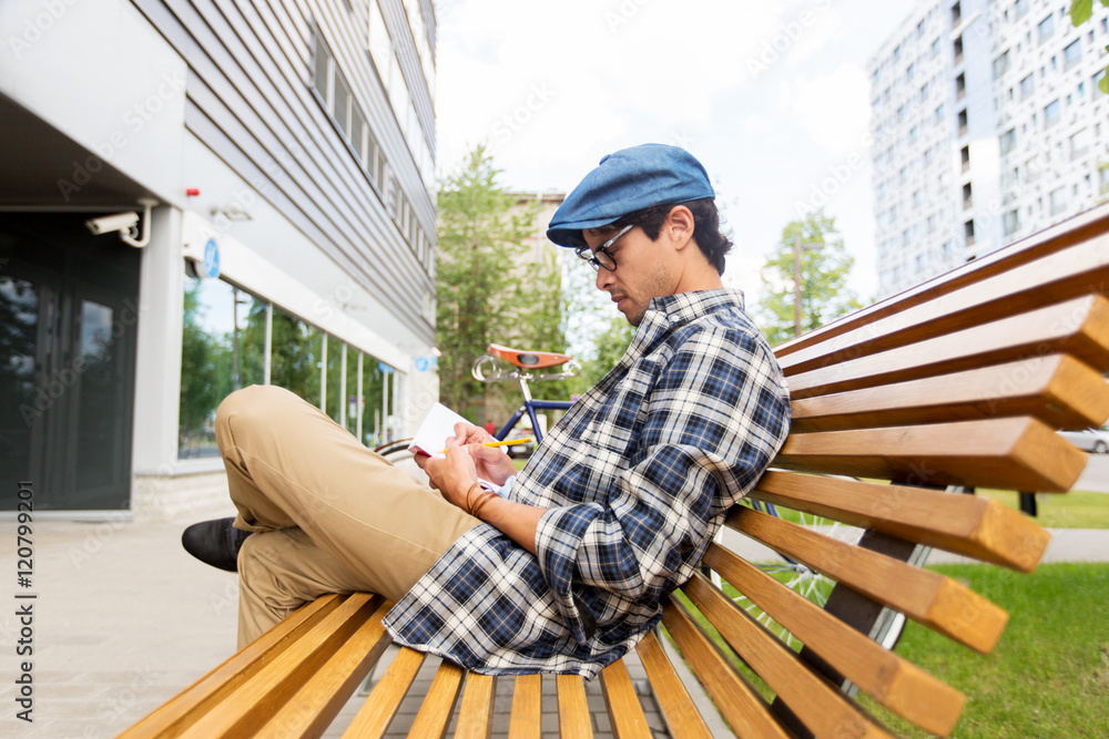 man with notebook or diary writing on city street man with notebook or diary writing on city street