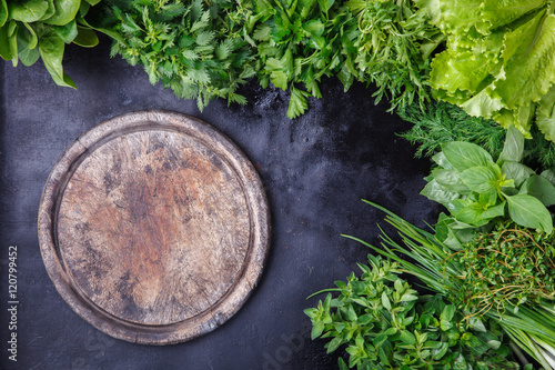 Various fresh herbs on a dark background.Weathered wood Board background for text.Vegetarian and healthily cooking concept.Copy space.selective focus.
