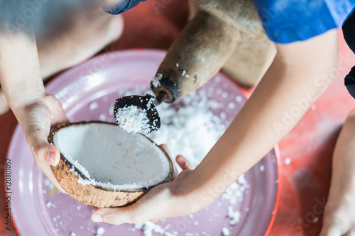 coconut grater and grate coconut into bowl 