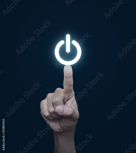 Hand pressing power button on blue background photo