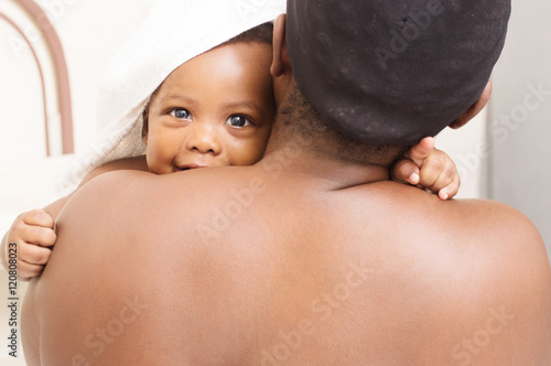 Fototapeta femme assise de dos caline son bébé  apres le bain