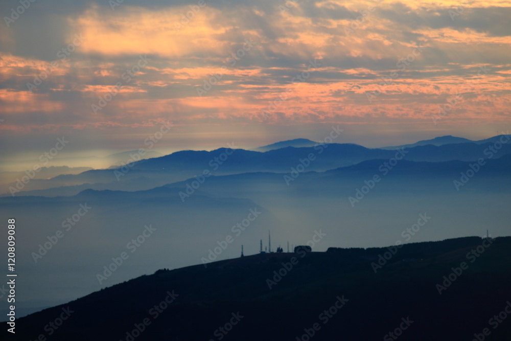 Cielo con tramonto spettacolare sui profili azzurri delle montagne