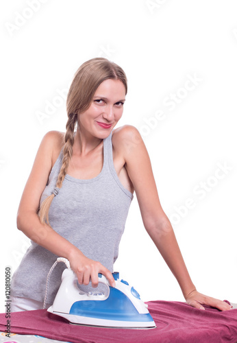 Smiling young woman ironing clothes