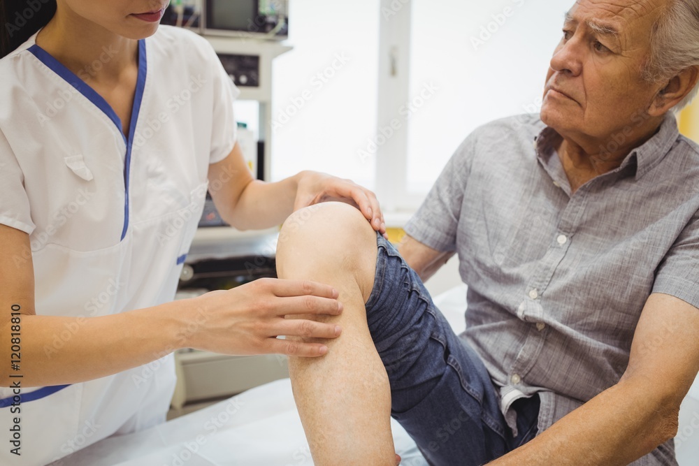 Obraz premium Female doctor examining patients knee