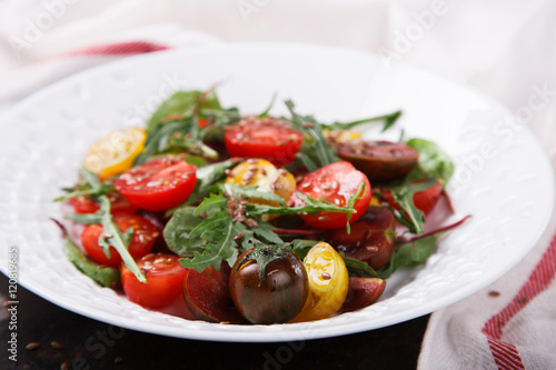 salad of fresh,colored cherry tomatoes with arugula and lemon dressing.selective focus.
