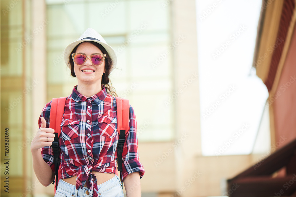 Obraz premium Portrait of a woman tourist showing thumbs up in the city