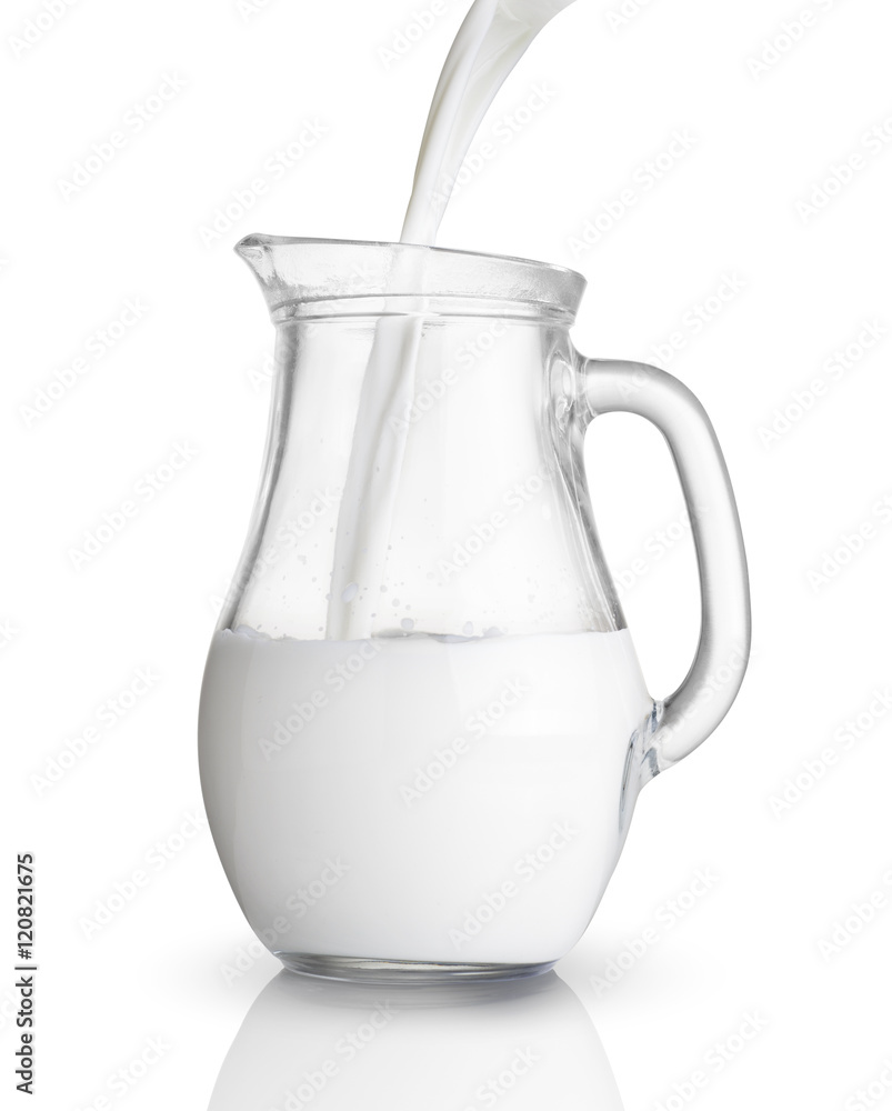 Pouring milk in a glass jug. Isolated on white Pouring milk in a glass jug. Isolated on white