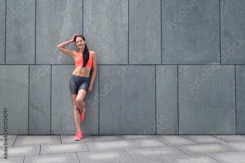 Attraktive sportliche Frau lehnt an der Wand © Lars Zahner