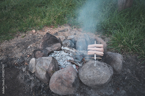 cooking sausages over a fire photo