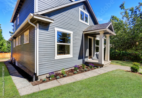 American house exterior with blue siding trim and small concrete floor porch