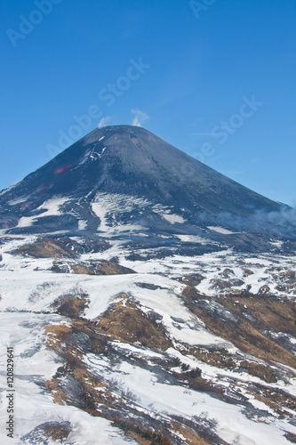 The views of the working Karymsky volcano in may 2016 with a hel