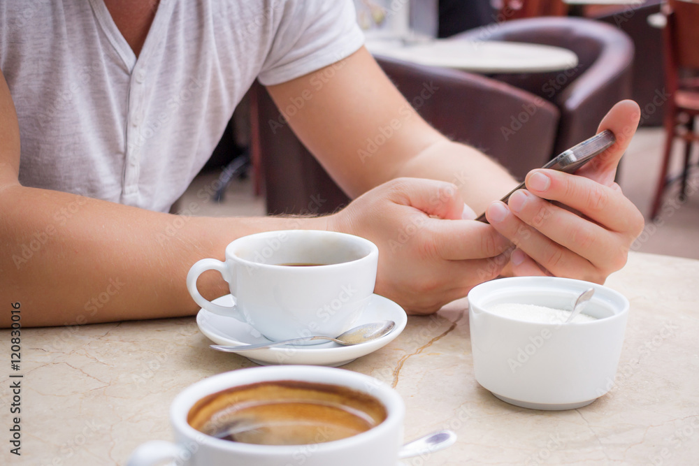 Man with smartphone at marble table with cup of coffee Man with smartphone at marble table with cup of coffee