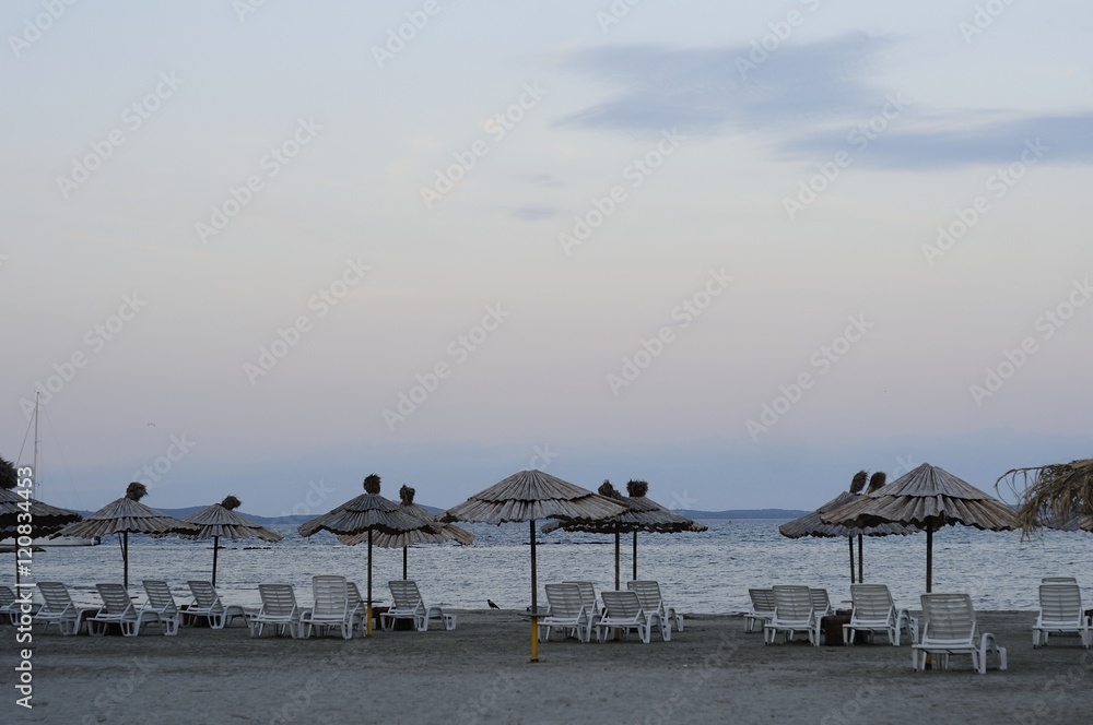 Empty deck chairs and bamboo umbrellas