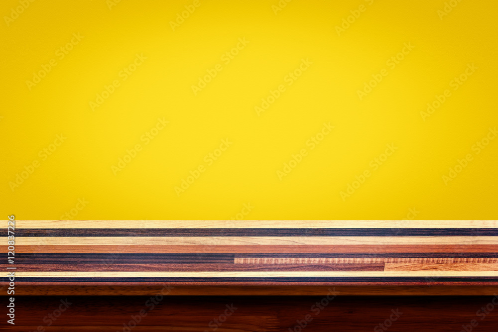 Empty top of wooden table on yellow gradient wall background.