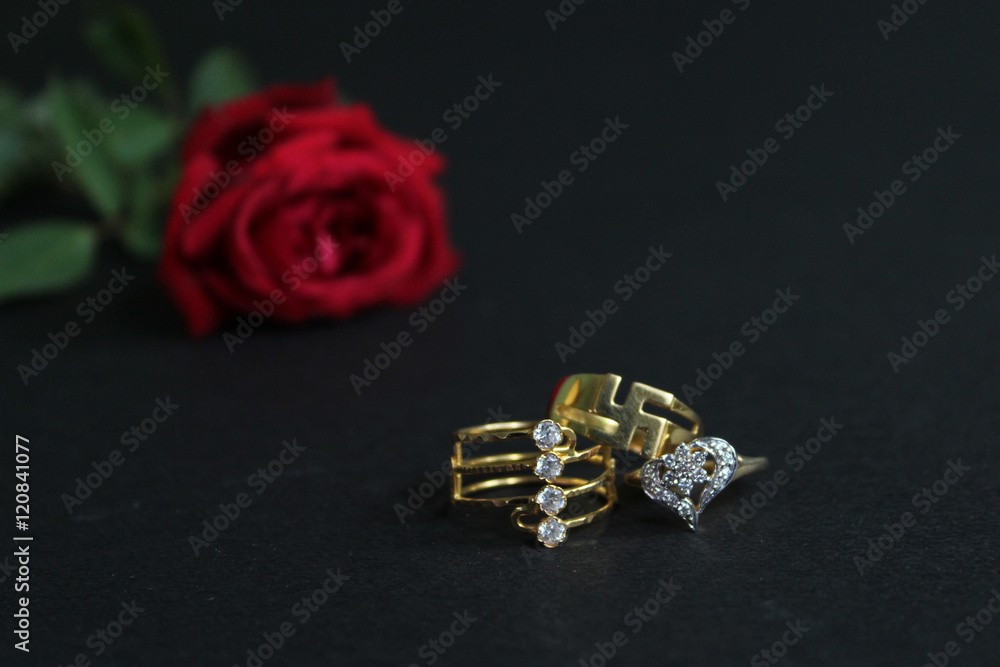 Red rose with wedding rings isolated on black background. Bride and Groom rings Red rose with wedding rings isolated on black background. Bride and Groom rings