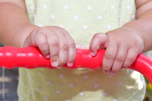 Hands of a baby girl holding her toy photo