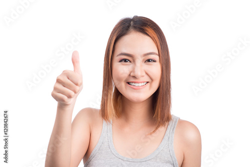 Cheerful lovely girl looking at camera showing thumbs up over wh