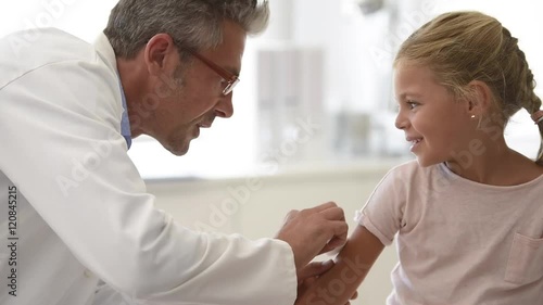 Doctor injecting vaccine to 5-year-old girl