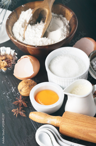 Baking ingredients for homemade pastry on dark rustic wooden background. Bake sweet cake dessert concept. Selective focus, toned vintage style