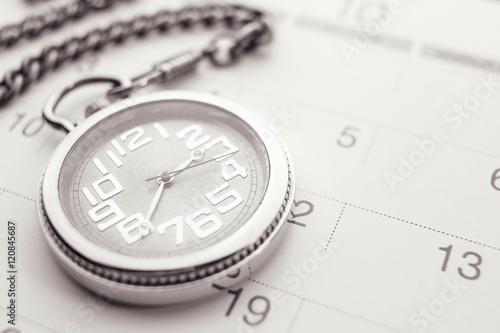 Old pocket watch on calendar page. vintage, black&white
