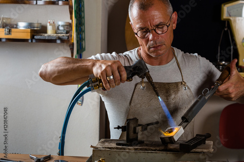 Vászonkép Goldsmith melting and casting metal with blowtorch