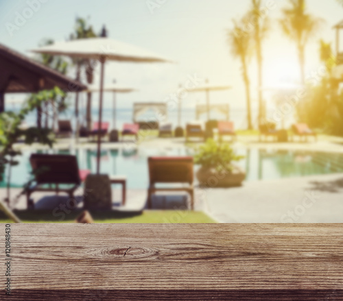 Empty wooden desk background  with blurred defocus tropical resort in sunrise  vintage tone