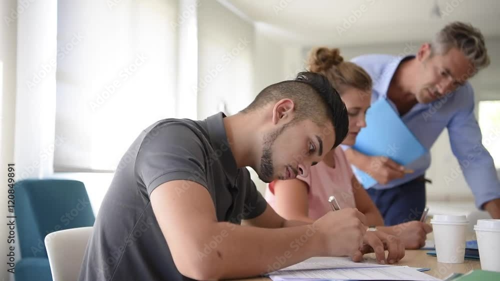 College students filling in registration forms College students filling in registration forms