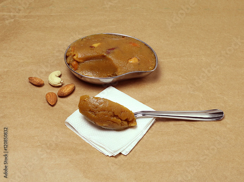 Indian sweet moong dal halwa scoop on a steel spoon. This sweet dish is a traditional and popular food made from split mung bean flour for festivals like Diwali.