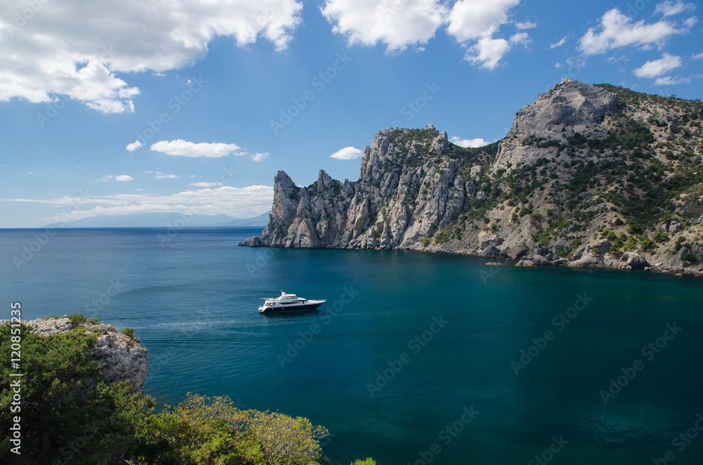 Yacht in the sea on blue sky background. Top view of Blue Bay and the mountains on the Black sea coast. Royal Beach, Crimea