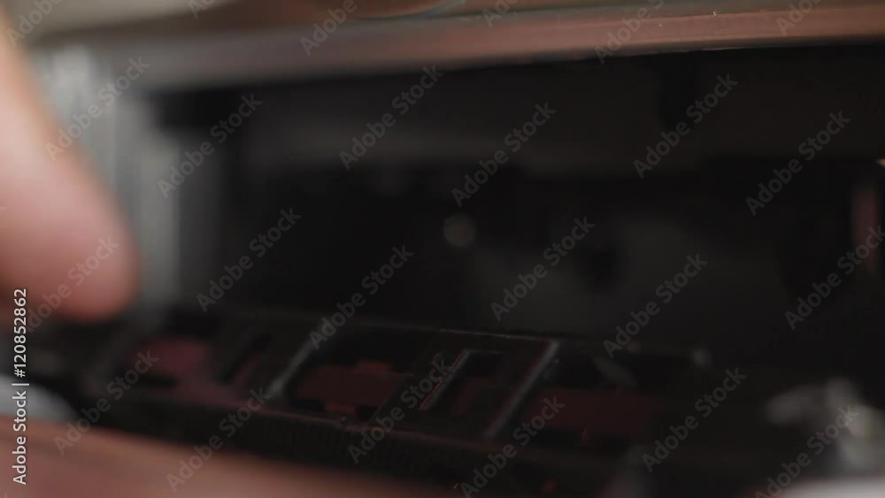 The man put and eject black tape in the recorder close-up The man put and eject black tape in the recorder close-up