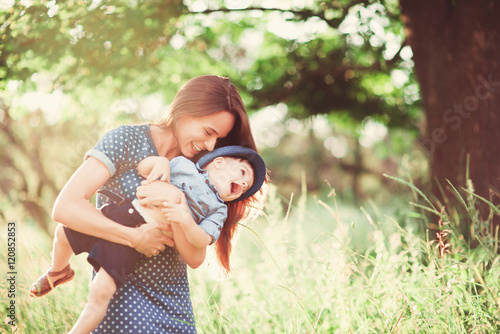Konstfotografi Loving mother holding son in her arms, plays with him and hugs him