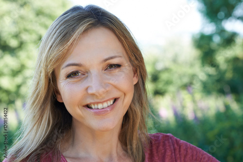 Outdoor Head And Shoulders Portrait Of Smiling Mature Woman