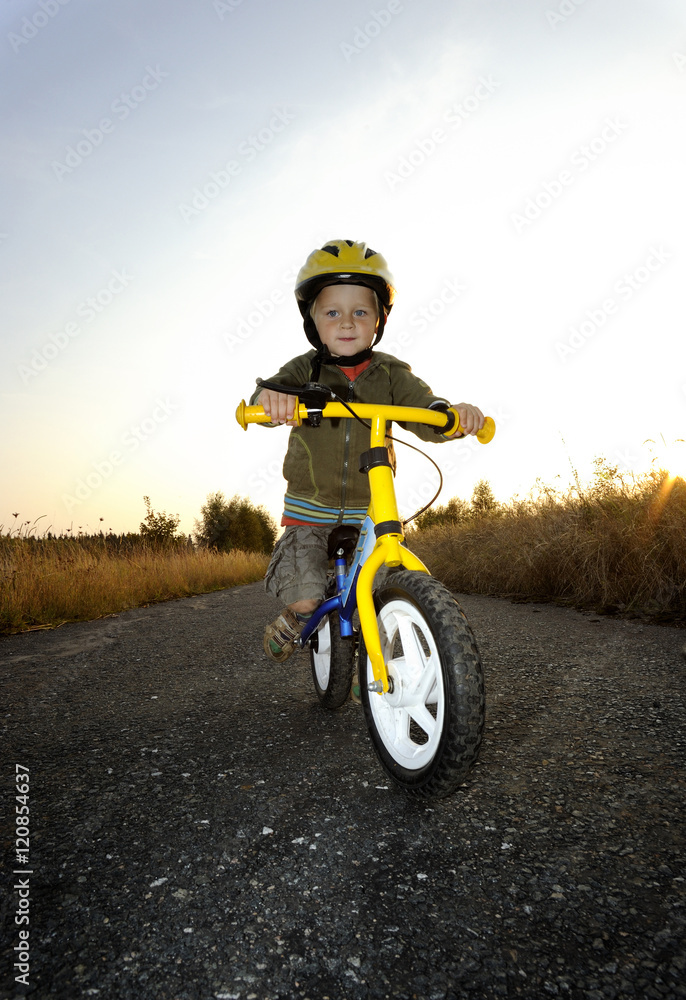 Baby boy riding on his first bike. Bike without pedals. Child learning to ride and balance on his two wheeler bike with no pedals.
Baby boy riding on his first bike. Bike without pedals. Child learning to ride and balance on his two wheeler bike with no pedals.