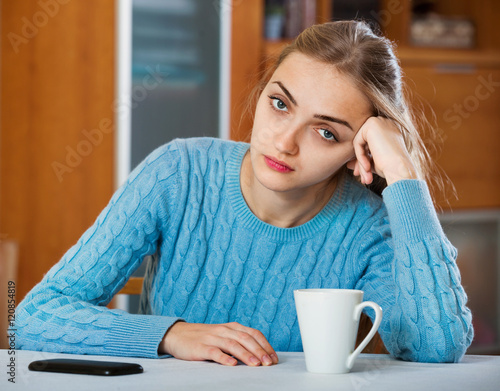 Upset adult girl waiting for important call