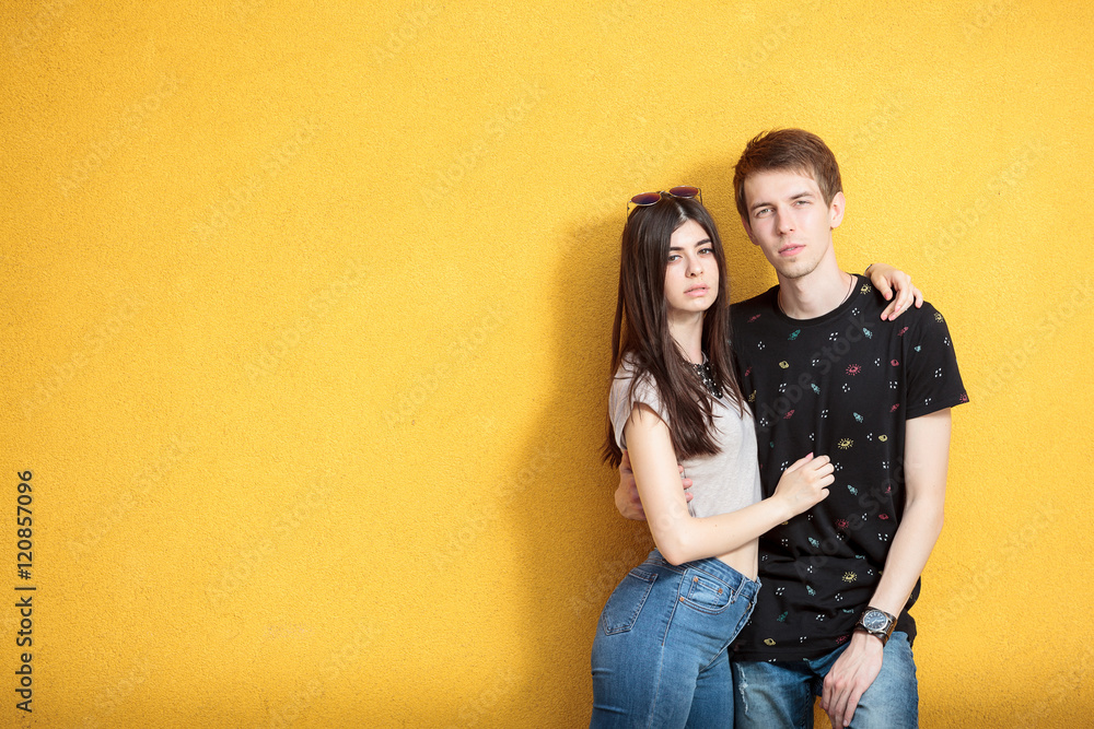 Very cool young couple on yellow wall